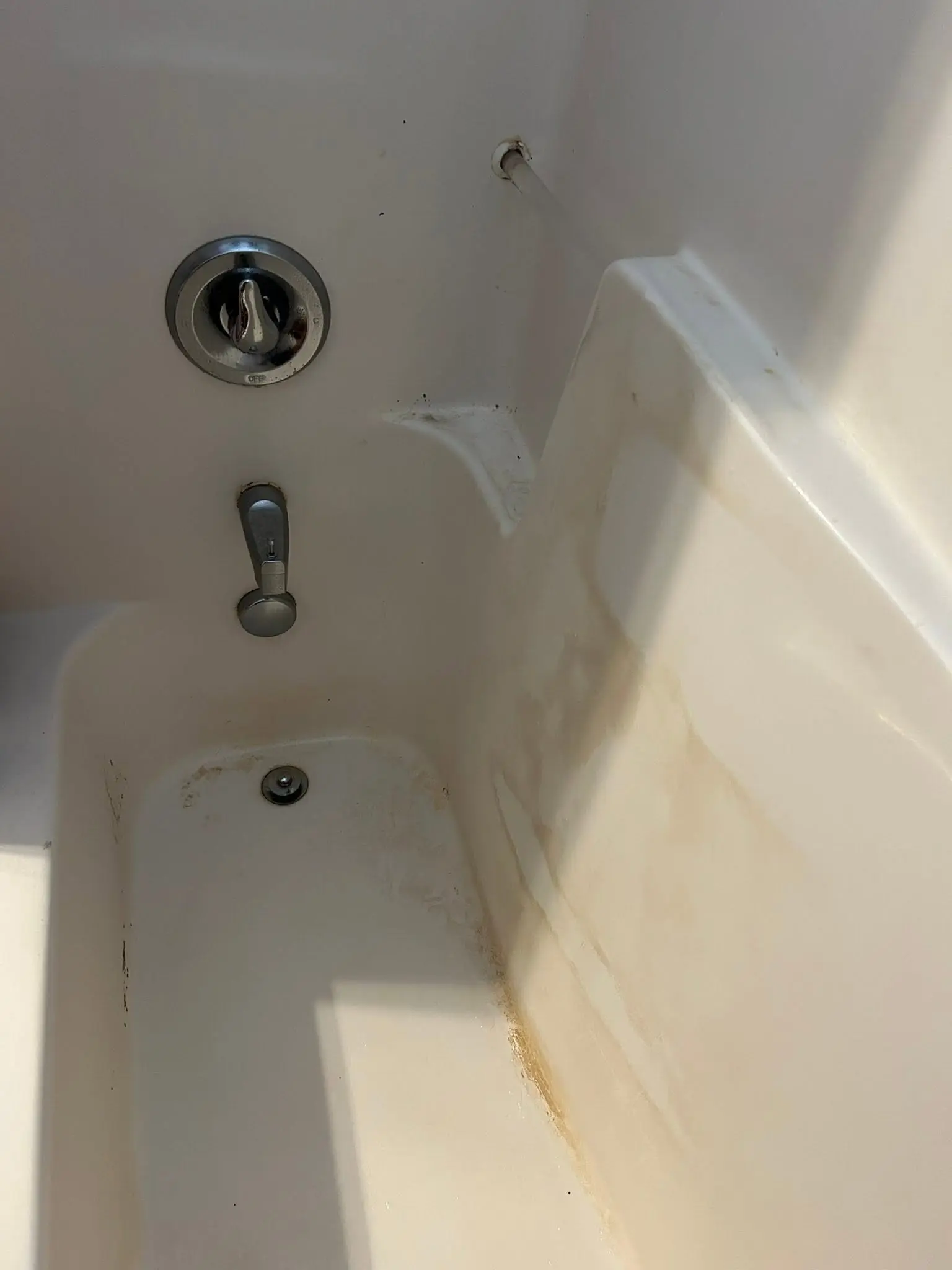 Bathtub with rust stains and discoloration before a Fresh As A Daisy deep clean