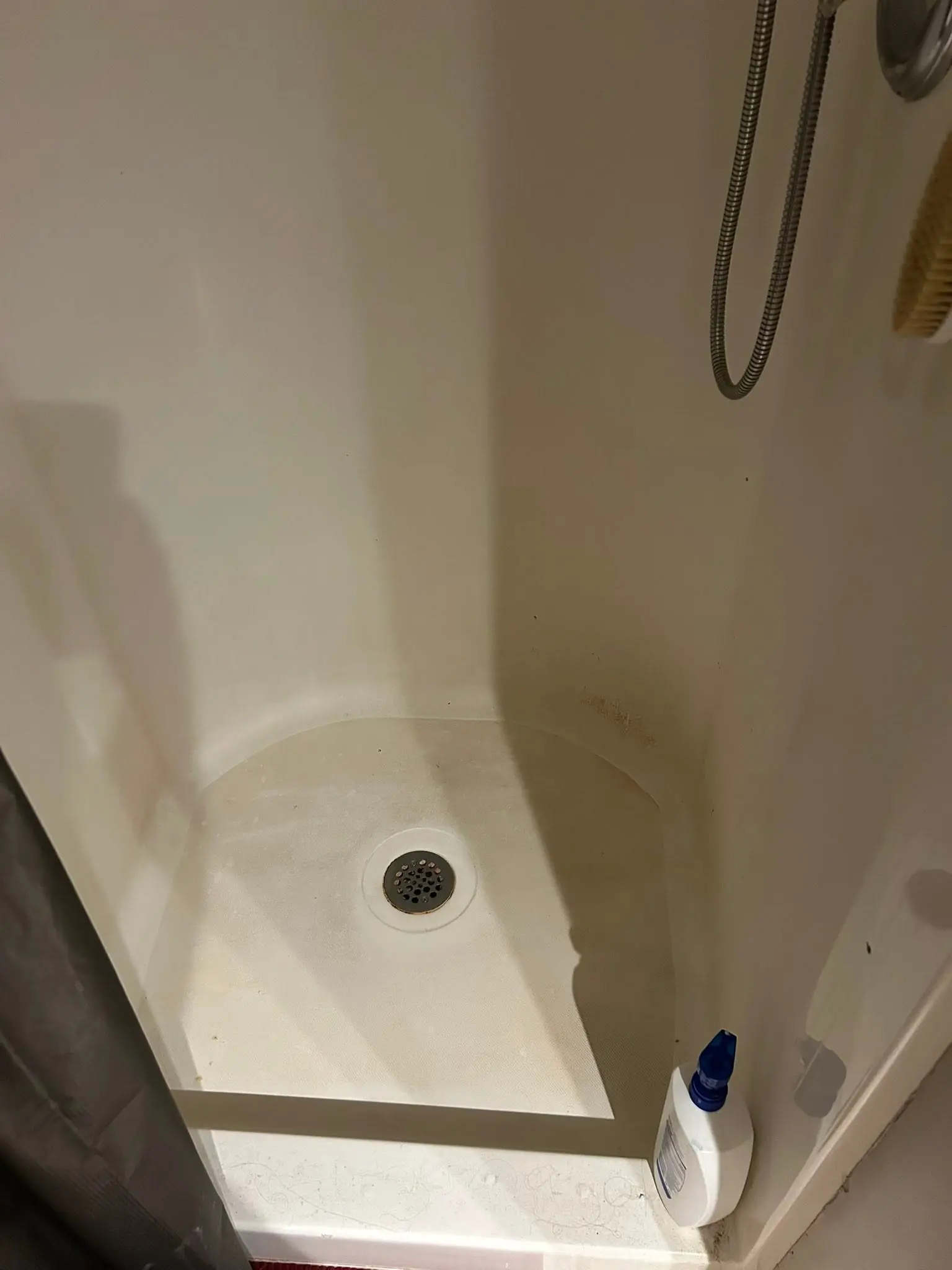 Fiberglass shower pan and drain scrubbed clean of soap buildup