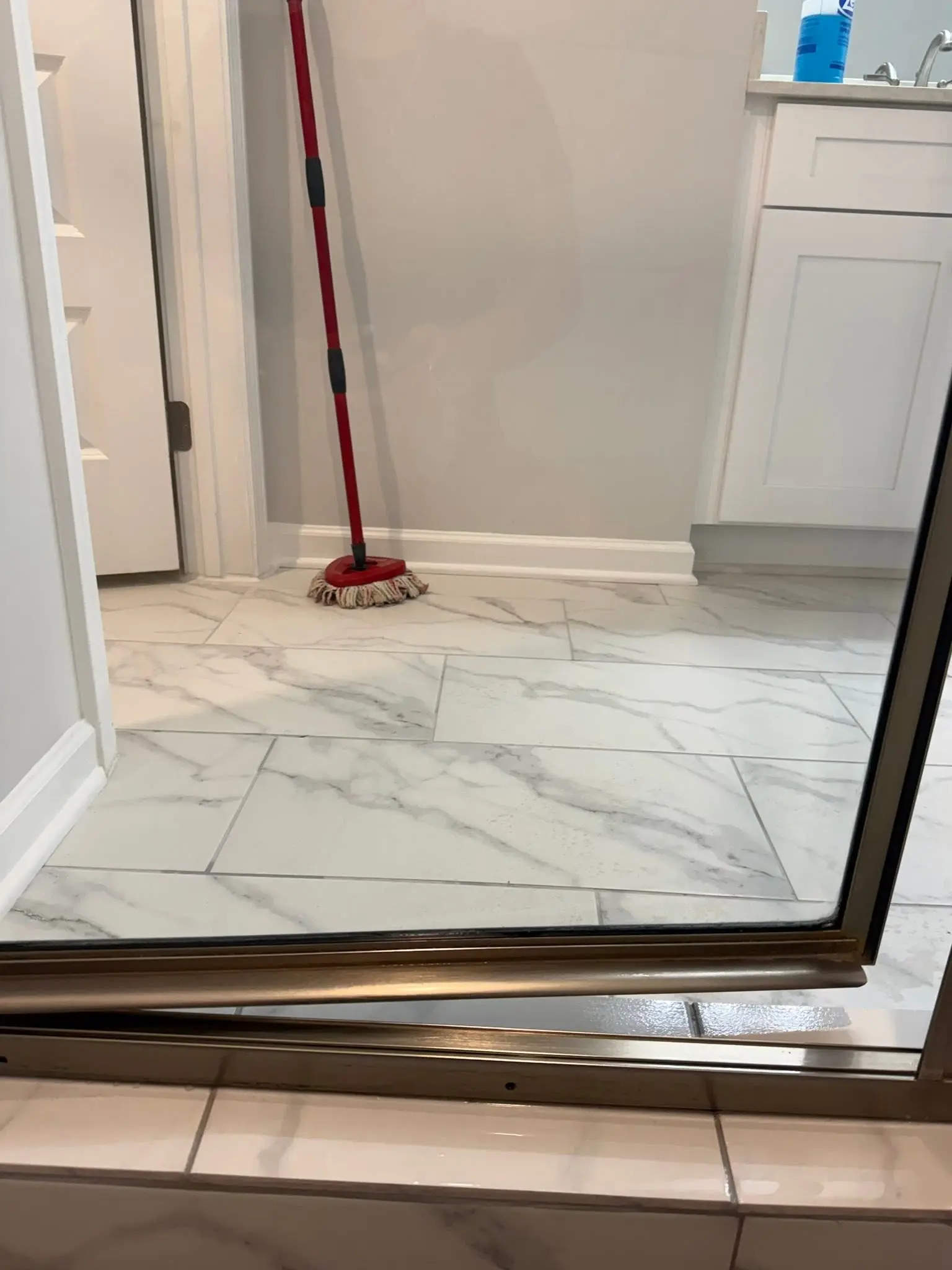 Marble floor being mopped during a move-out cleaning in a vacant Georgia home